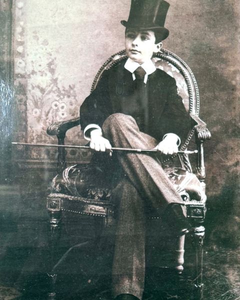 Ritratto giovanile in studio, con cilindro e bastone.